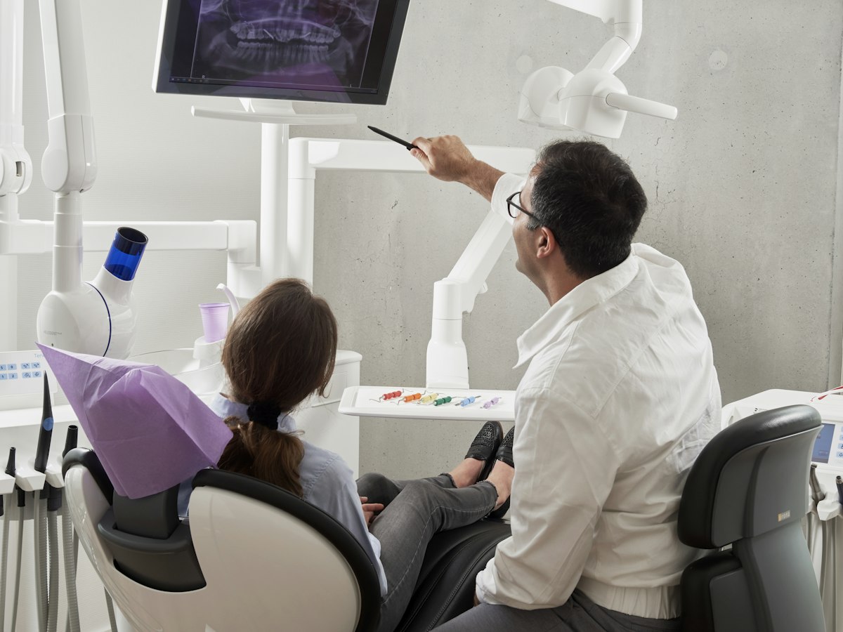 Dentist reviewing an x-ray with a patient - collecting outstanding dental balances without awkward calls